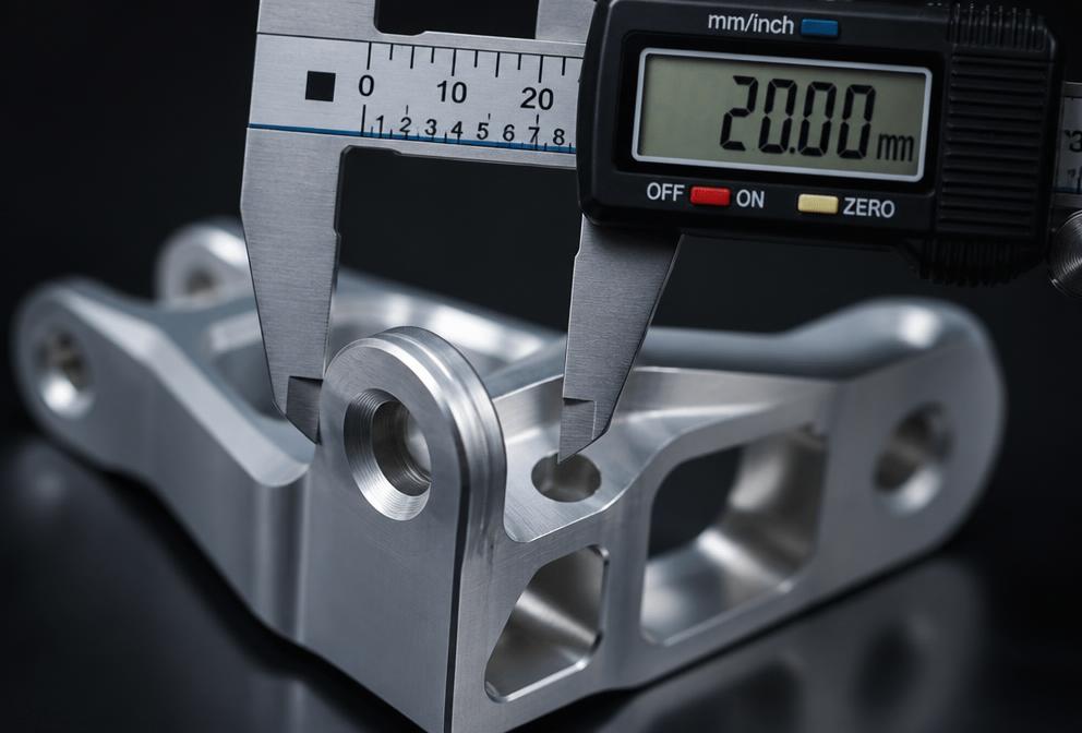 Close-up dimensional inspection of a machined aerospace bracket